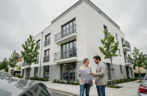 Couple devant un programme immobilier neuf à Quimper, façade moderne avec balcons et espaces verts